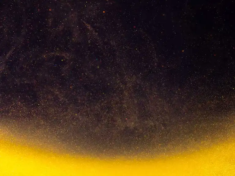 A photo of floating particles shimmering in golden light